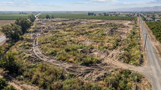 Raw uneven terrain before commercial pad excavation in Stockton Central Valley